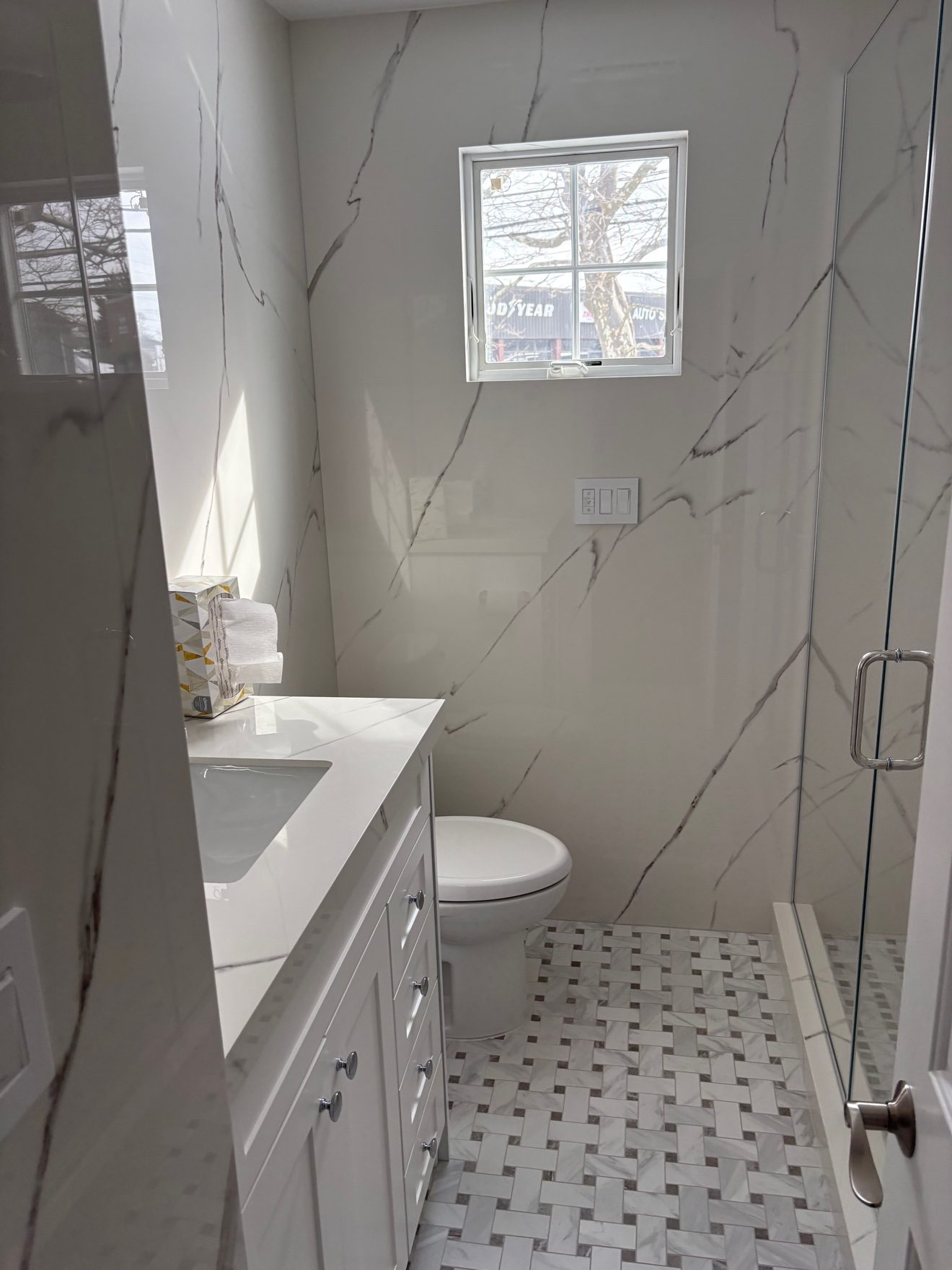 Bathroom remodel — vanity, glass shower, and marble-look tile.